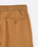 Close-up of the rear welt pocket and elasticated waistband on the Dekk Trouser in light brown