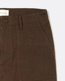 Close-up of the angled front patch pocket and waistband on the Coup Trouser in brown